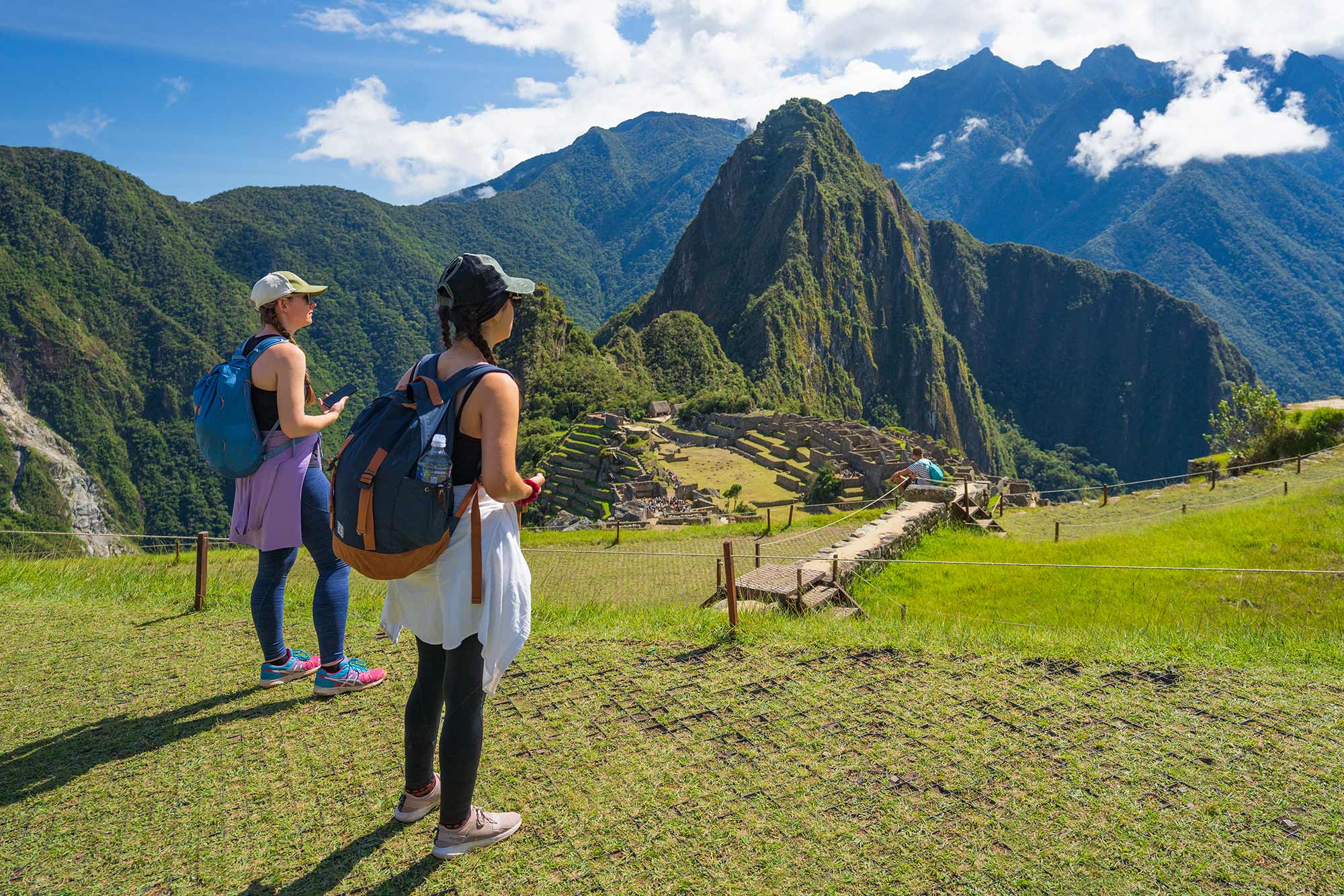 Traveler with backpack overlooking Machu Picchu citadel with proper hiking gear